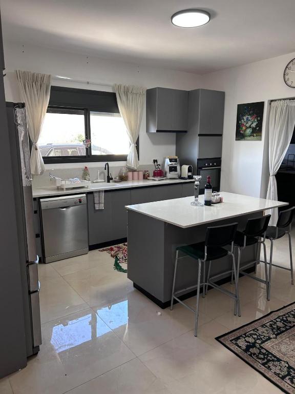 a kitchen with a island in the middle of a room at הבית על ההר בכרמל in ‘Isfiyā