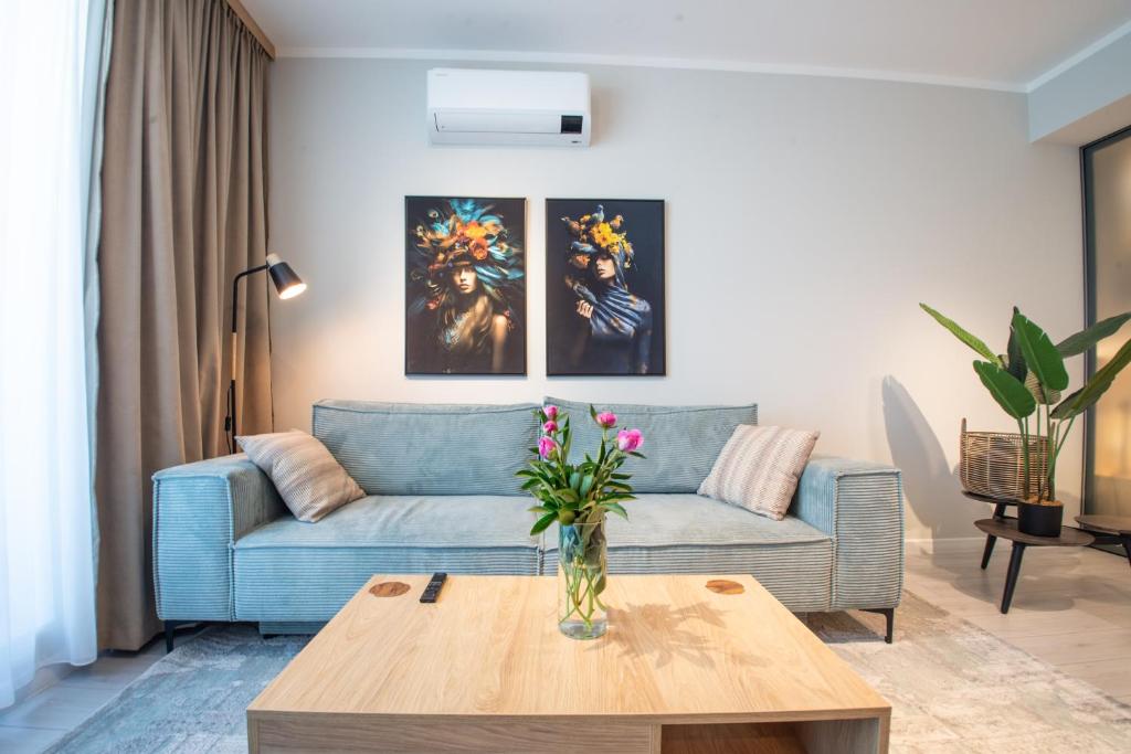 a living room with a blue couch and a table at Studio President 80 in Craiova