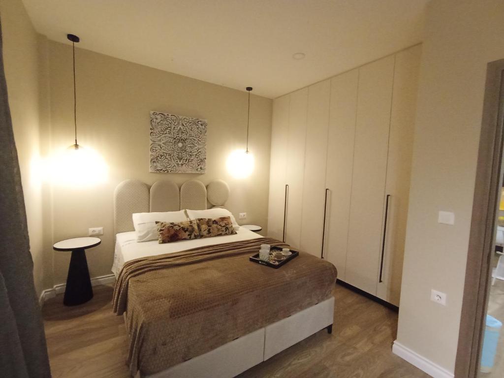 a bedroom with a large bed and two lights at Obassys View in Faraklata