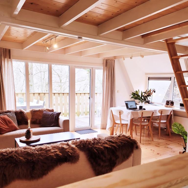 a living room with a couch and a table at A Wood Lodge - zwembad - relax - natuur in Durbuy