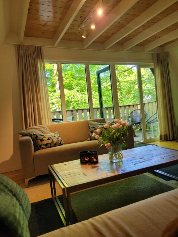 a living room with a couch and a table at A Wood Lodge - zwembad - relax - natuur in Durbuy