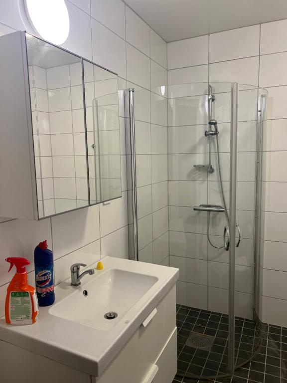 a white bathroom with a sink and a shower at Cozy double bed room in Eslöv in Eslöv