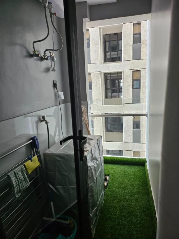Habitación con suelo verde y ventana en Josham Luxury Apartment, en Nairobi