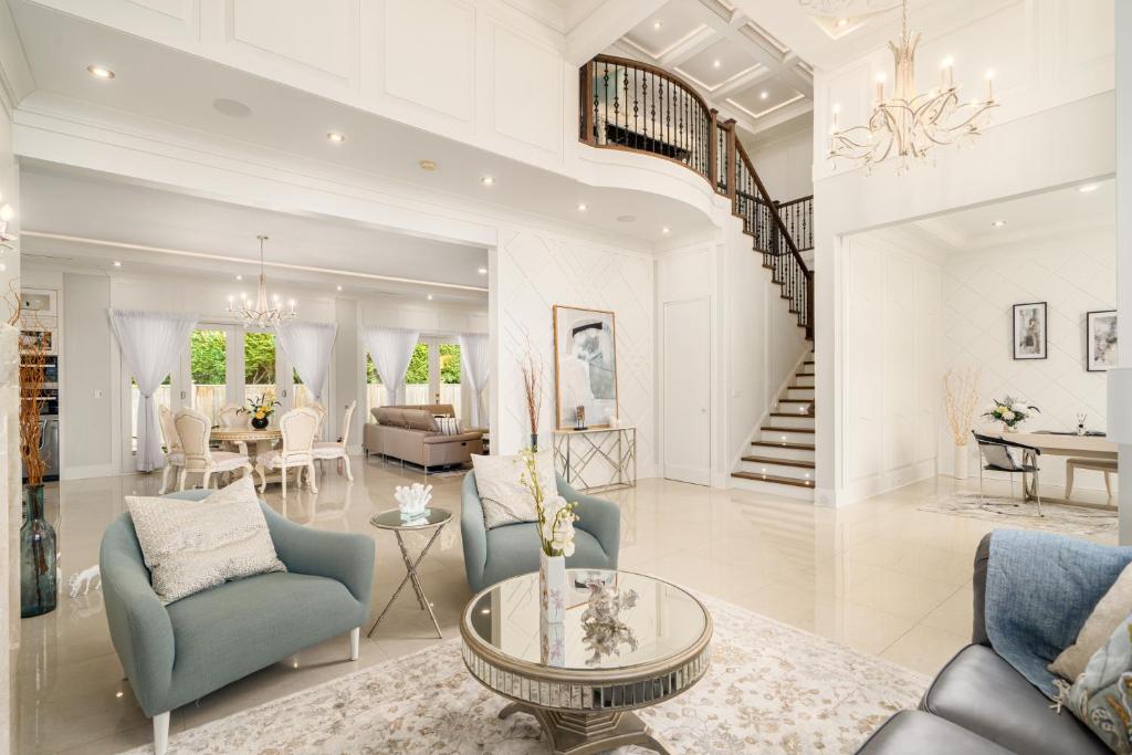 a living room with blue chairs and a dining room at Vancouver Shangrila House in Richmond