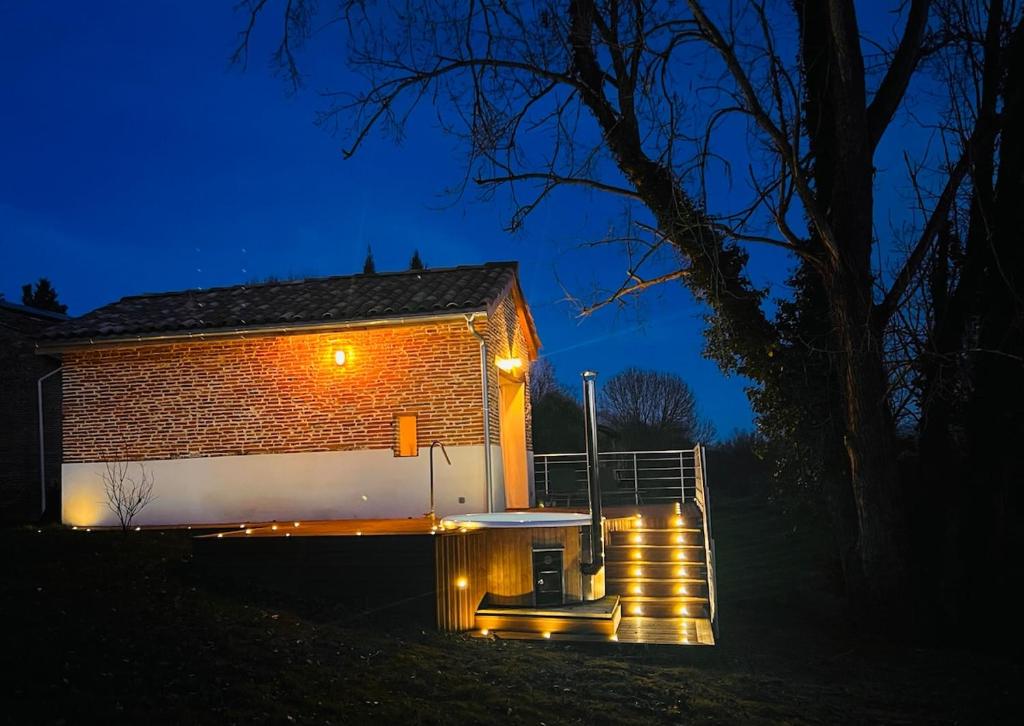 un bâtiment avec des lumières allumées la nuit dans l'établissement Bétia Cocoon SPA et Sérénité, proche Canal du Midi, à Grisolles
