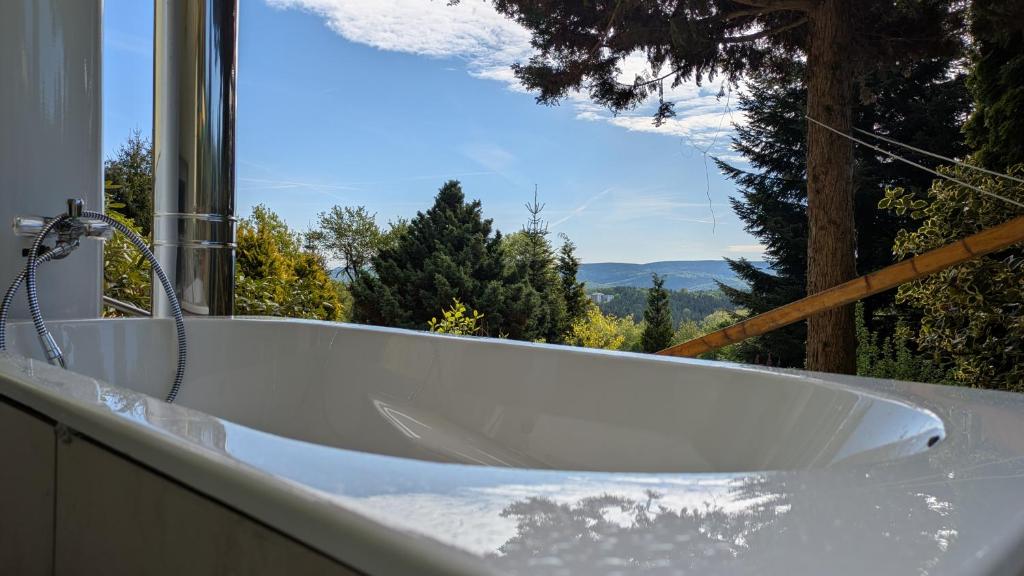 a bath tub in front of a window with a view at Randfichte - die Hütte direkt am Wald 