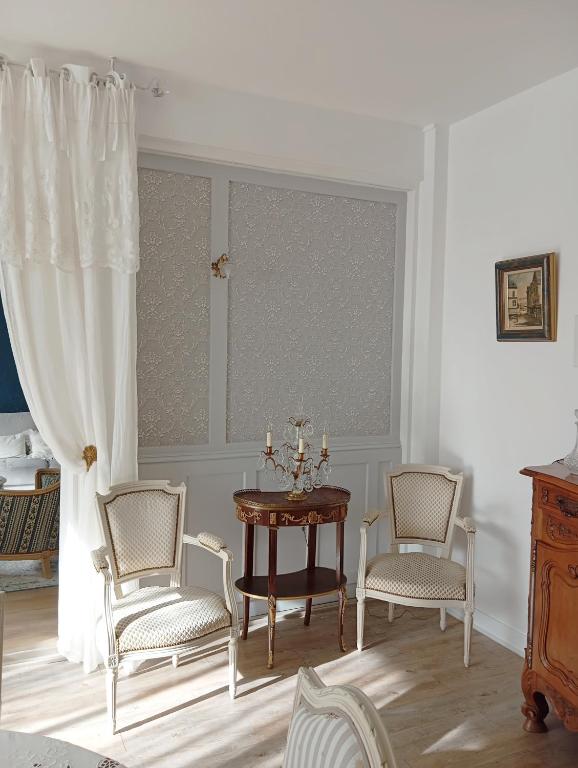 une salle à manger avec une table et des chaises et une fenêtre dans l'établissement Bel appartement, à Montluçon