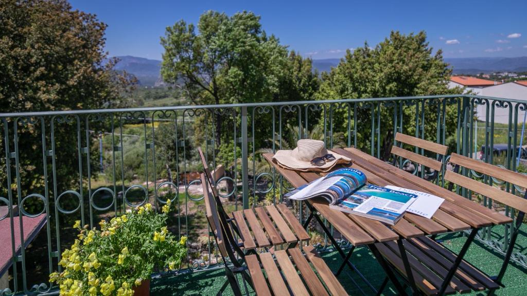 a wooden table with a hat sitting on a balcony at Villa del noce - Dorgali in Dorgali