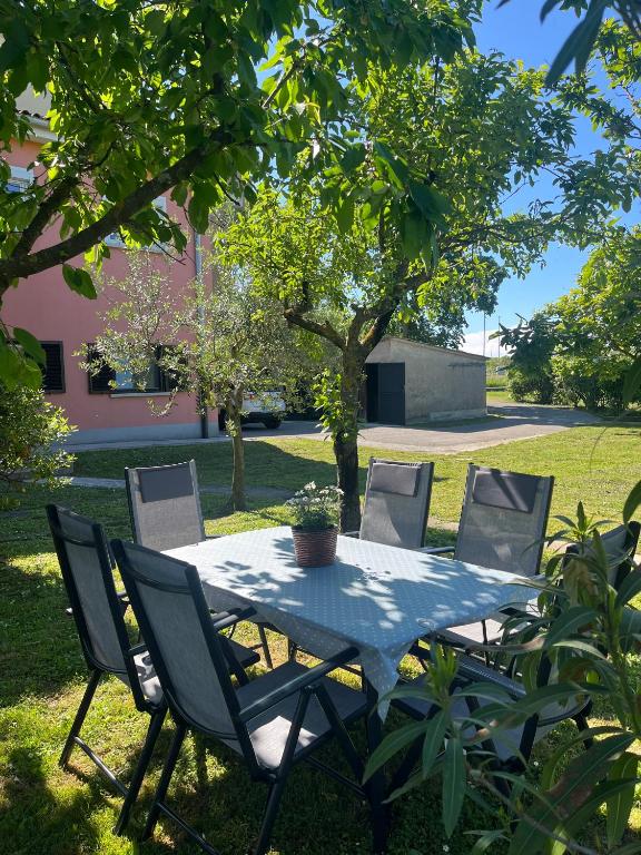 a table and chairs in a yard with a tree at Stipos Apartment in Koper