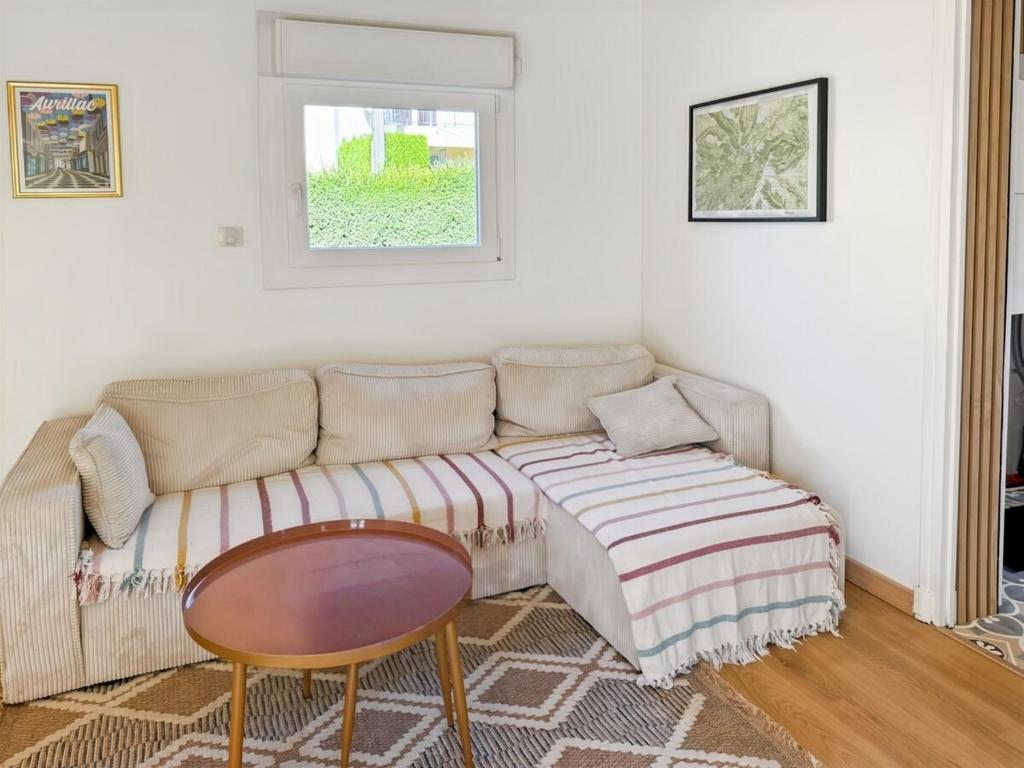 ein Wohnzimmer mit Sofa und Tisch in der Unterkunft Maison familiale en montagne - 6 pers - Le Lioran in Saint-Jacques-des-Blats