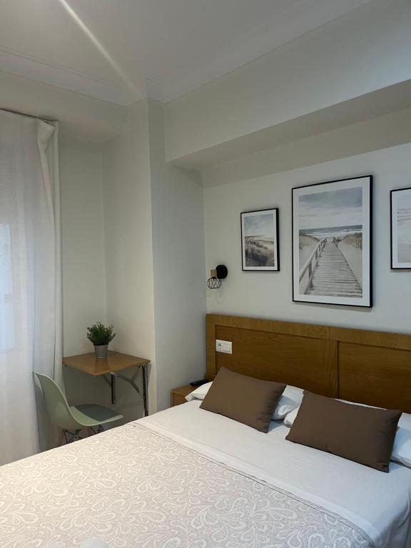 sypialnia z dużym białym łóżkiem z 2 poduszkami w obiekcie Pension Angelines, Sneuu Hostel Santander w mieście Santander