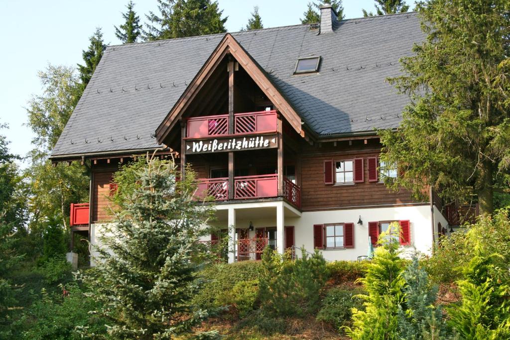 ein großes Haus mit einem Gameradach in der Unterkunft Ferienanlage Zum Silberstollen 2 Häuser am Berg Polderhof und Weißeritzhütte in Kurort Altenberg