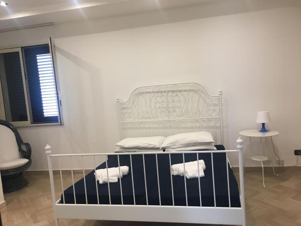a white bed with towels on it in a room at Centralissima casa Delfino in Gallipoli