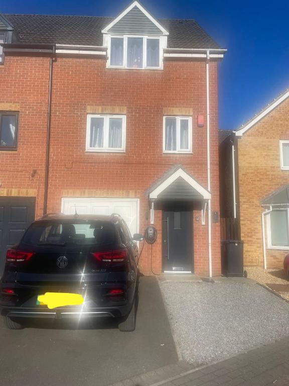 une voiture garée devant une maison en briques dans l'établissement Lim's Cottage, à Armthorpe