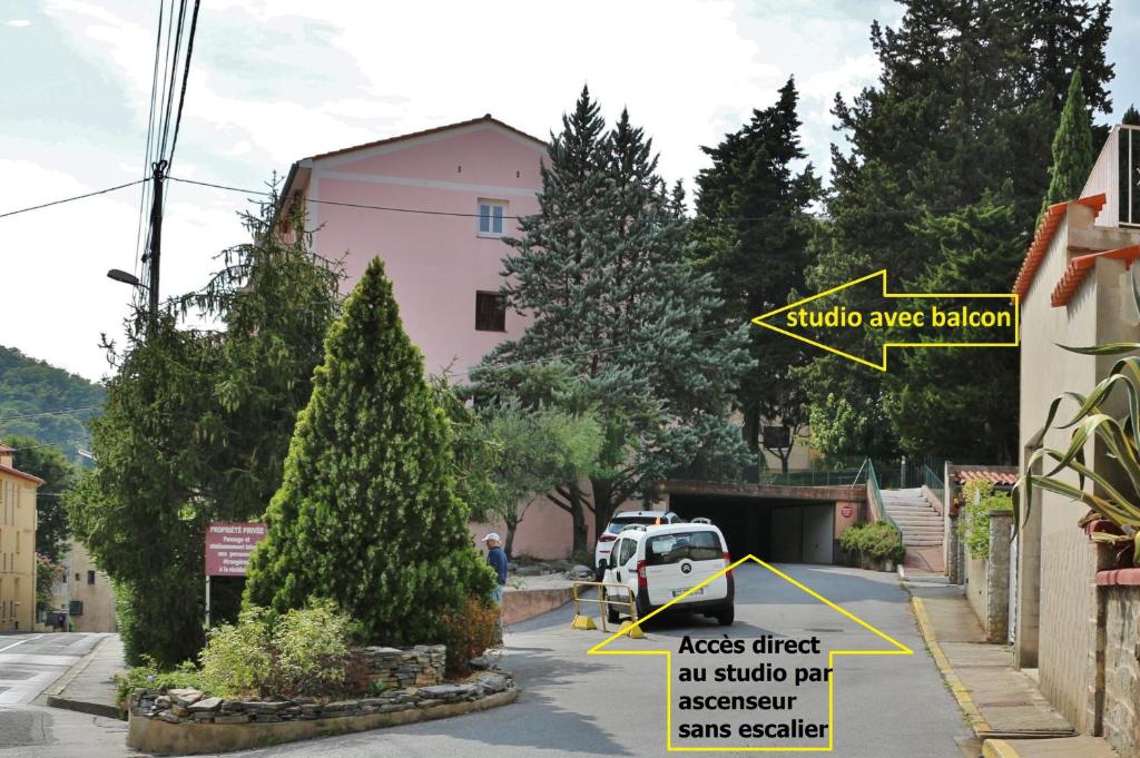 znak uliczny przed różowym budynkiem w obiekcie Studio classé 2 étoiles à 5 minutes du centre ville et 10 des Thermes w mieście Amélie-les-Bains-Palalda