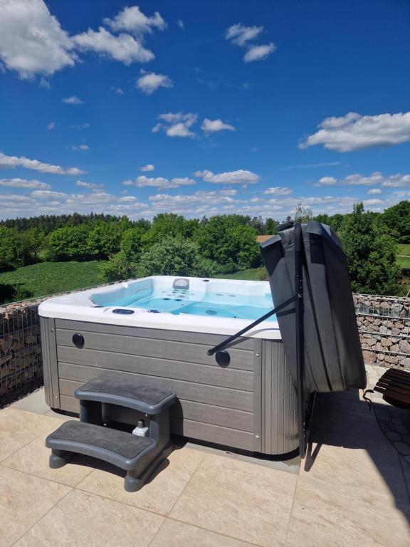 a hot tub sitting on a patio with a television at Chalet Heimatzeit in Reichenbach