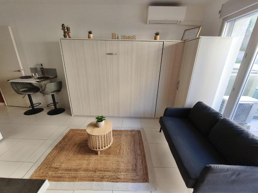 un salon avec un canapé et une table dans l'établissement Studio calme et paisible, climatisé avec terrasse au dernier étage, 100m du tramway et 20 min de la promenade des anglais, à Nice