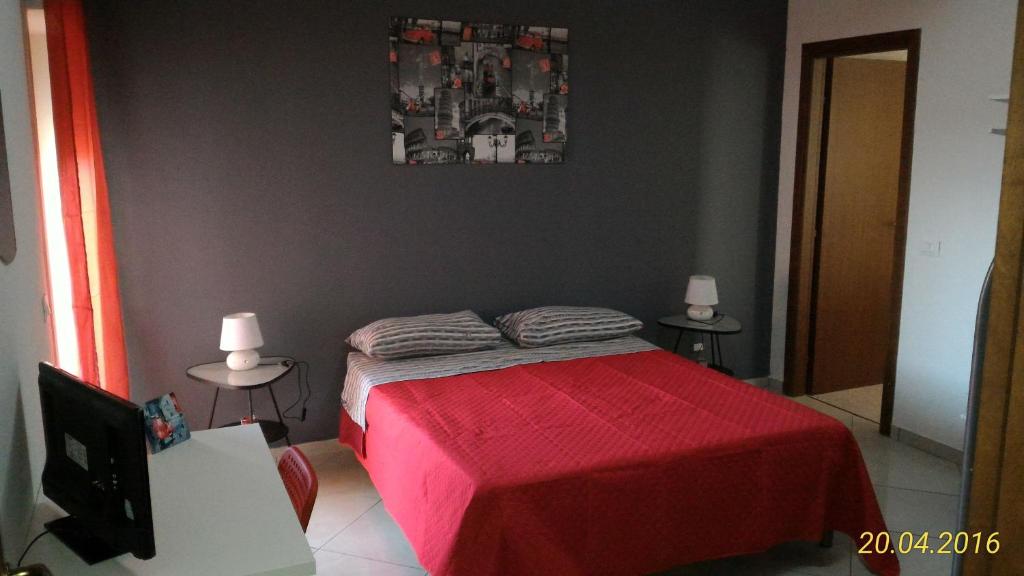 een slaapkamer met een bed met een rode sprei bij Bed and Breakfast Oasi in Reggio di Calabria