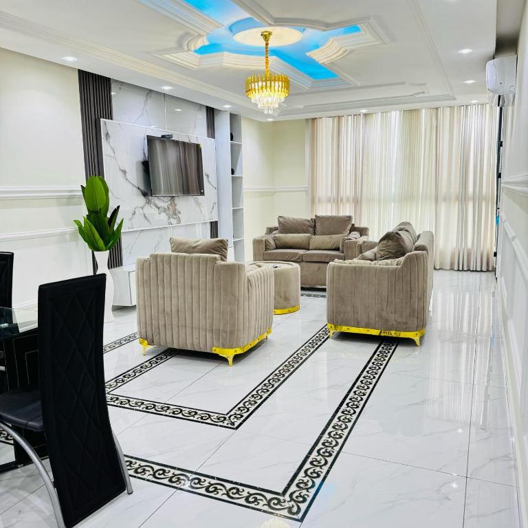 a living room with two couches and a tv at Cité La Vie in Douala