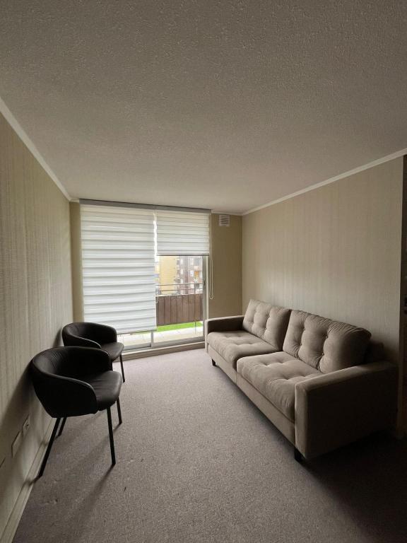 a living room with a couch and a window at Depto amoblado 3D 2B in San Pedro de la Paz