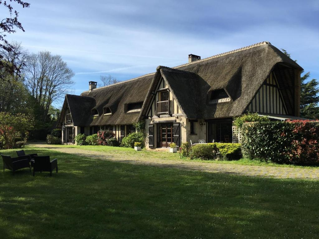 a large house with a gambrel roof on a lawn at L'Ile Normande in Hardencourt-Cocherel