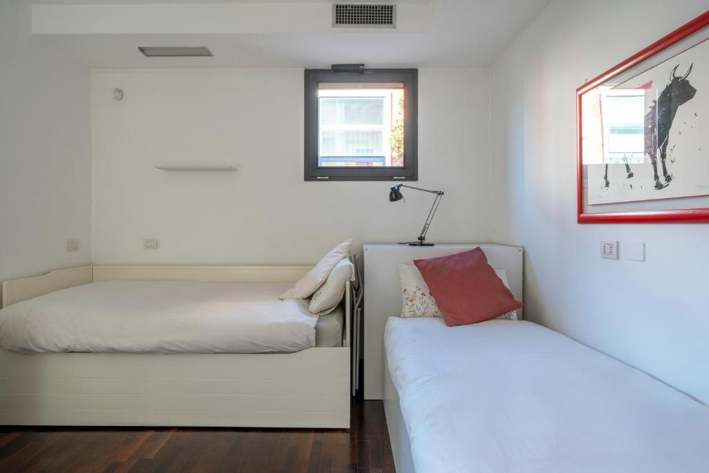 Letto o letti in una camera di RED LOFTY Milano- Loft moderno comodo per Ippodromo, San Siro, Rho Fiera-MiCo e Politecnico, parking