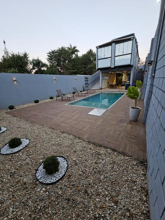 a backyard with a swimming pool and a house at Casa Container in Águas de Lindoia