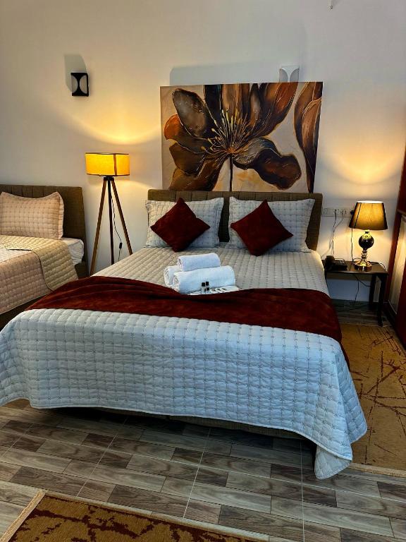 1 dormitorio con 1 cama grande con una pintura floral en la pared en Starmax City Hotel's YALOVA, en Yalova