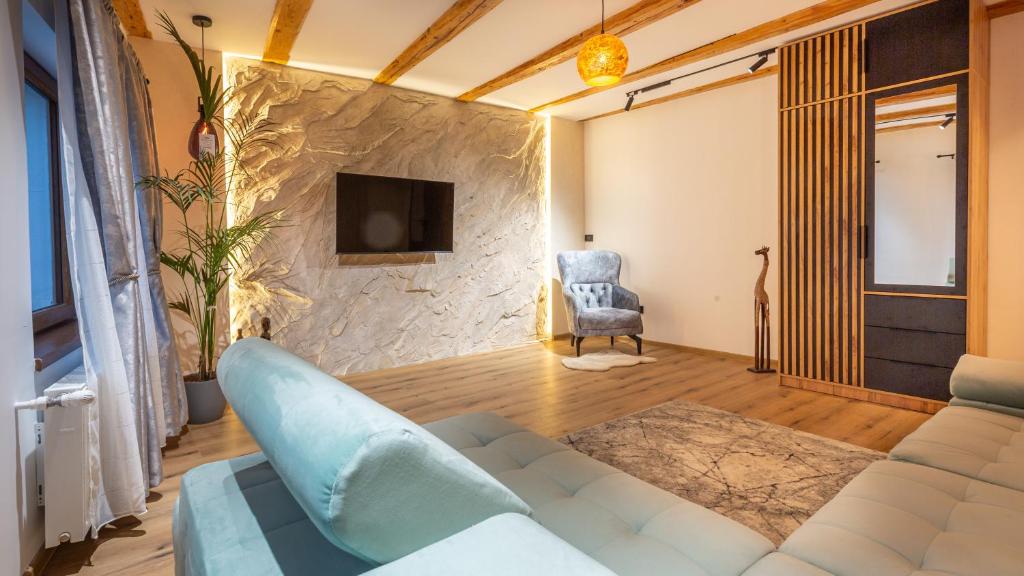 a living room with a couch and a tv at Sun x Mountains - Old Town in Braşov