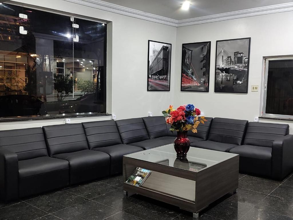a living room with a couch and a table with flowers at Center Plaza Hotel in São Paulo