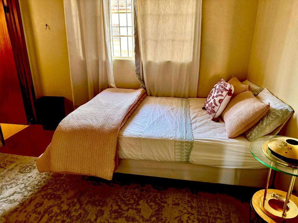 a small bed in a room with a window at Karibu House in Tucson