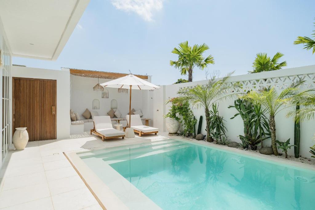 a swimming pool in a villa with palm trees at Nisí Villas Bingin, Uluwatu in Uluwatu