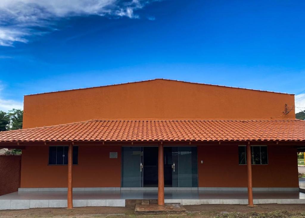 an orange building with a red roof at Ipê Dourado Hotel in Natividade