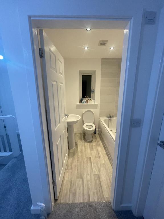 a bathroom with a toilet and a tub and a sink at blackburn home in Blackburn