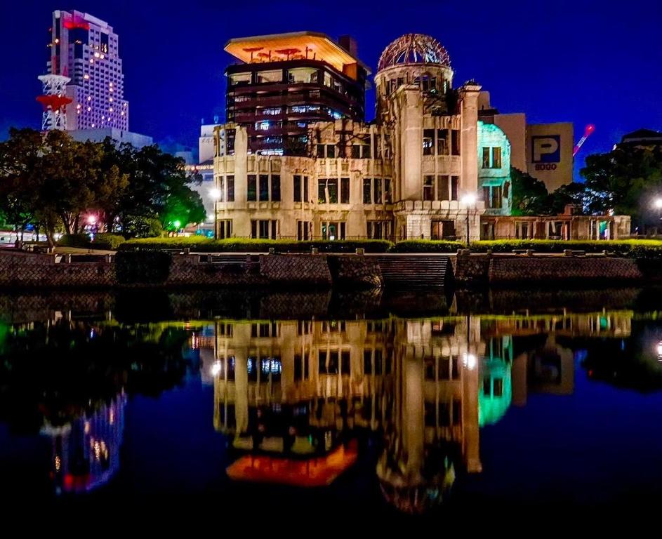 広島市にある広島Riverside house第2ひまわり201号室の夜の水面に映る建物