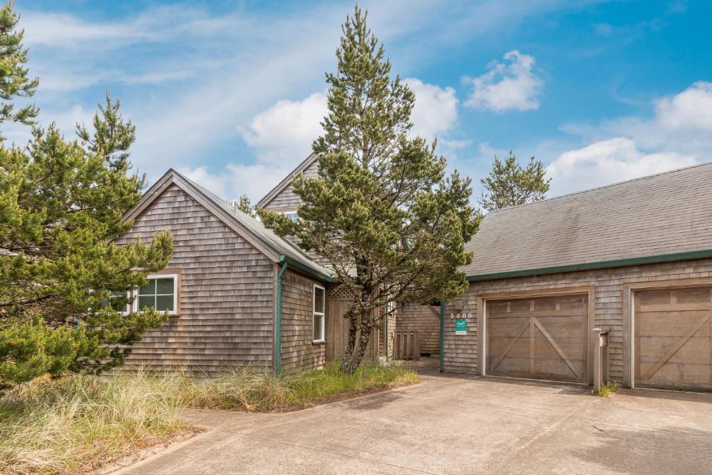 een huis met een garage en een boom bij Getaway in Pacific City