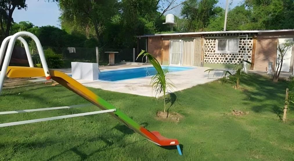 un tobogán en un patio junto a una piscina en Cabaña Las Catas, en General Enrique Mosconi