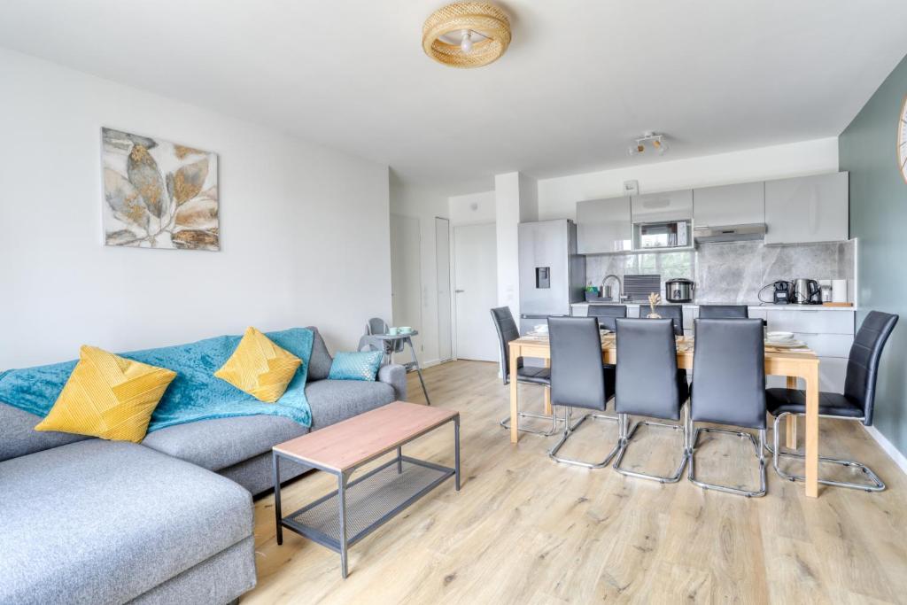 a living room with a couch and a table and chairs at Lafya : ParisNord, Villepinte, CDG, StadedeFrance in Le Blanc-Mesnil