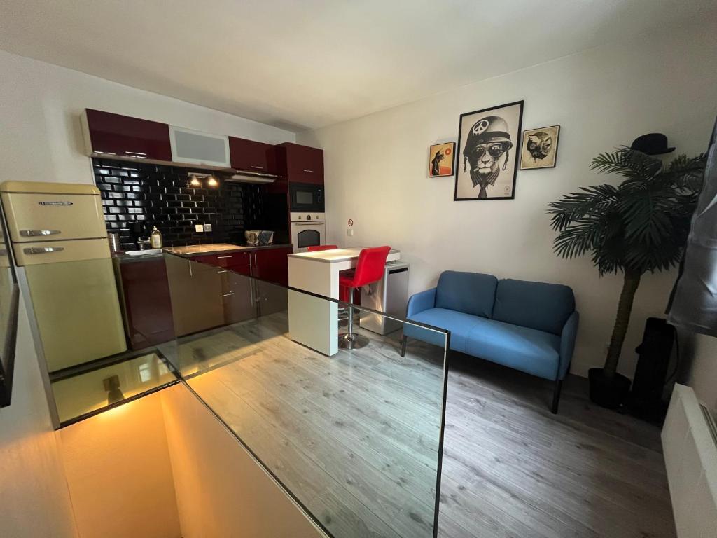 un salon avec un canapé bleu et une cuisine dans l'établissement Petit Dupleix atypique Porte Maillot F3, à Paris