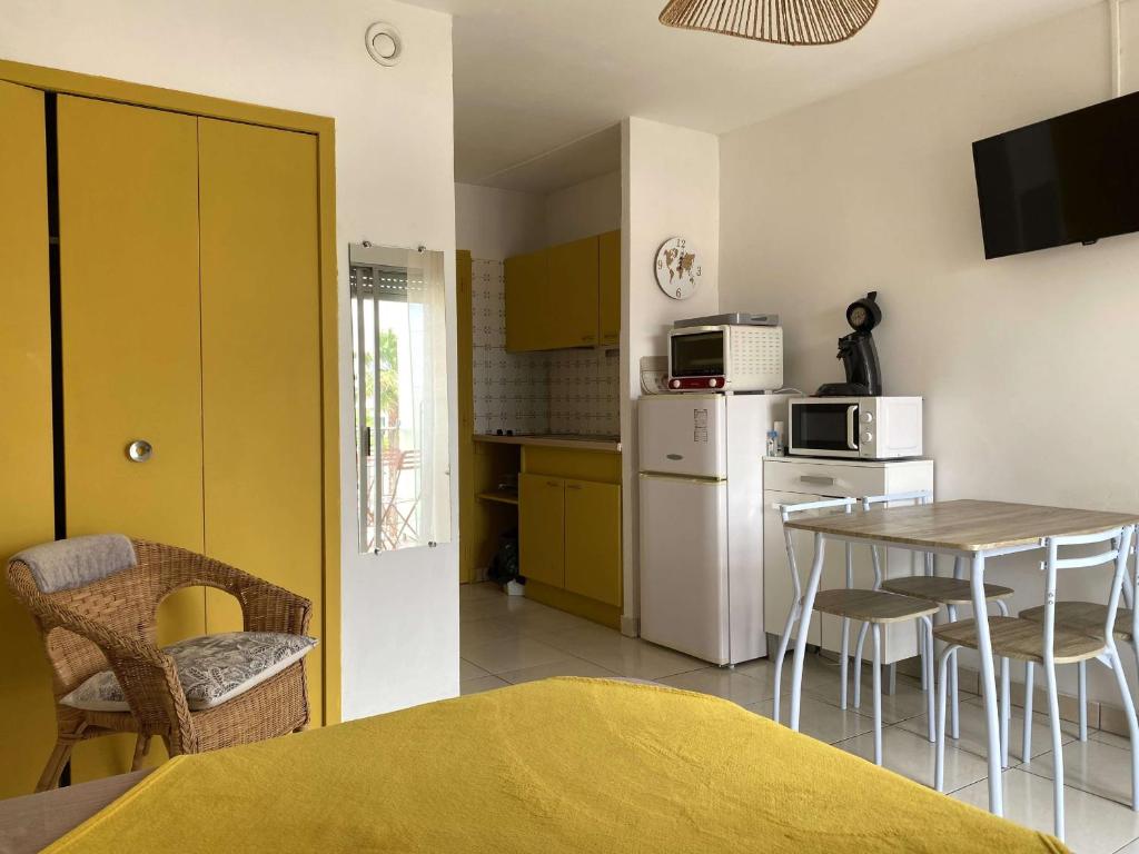 une cuisine avec une table et un réfrigérateur blanc dans l'établissement Studio rénové avec balcon et WIFI à Balaruc-les-Bains - FR-1-553-303, à Balaruc-les-Bains