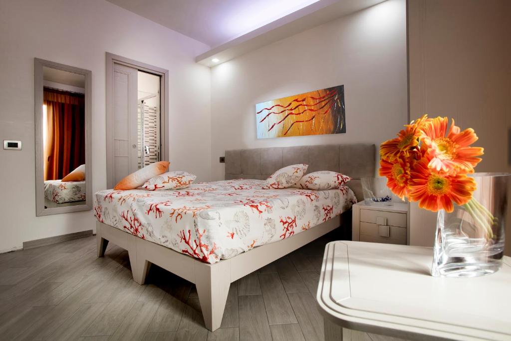 a bedroom with a bed and a vase with flowers at Monte Monaco B&B in San Vito lo Capo