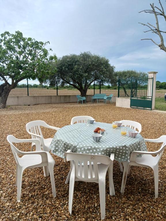 - une table avec quatre chaises et une table avec des boissons dans l'établissement Mas la Daune, à Le Cailar