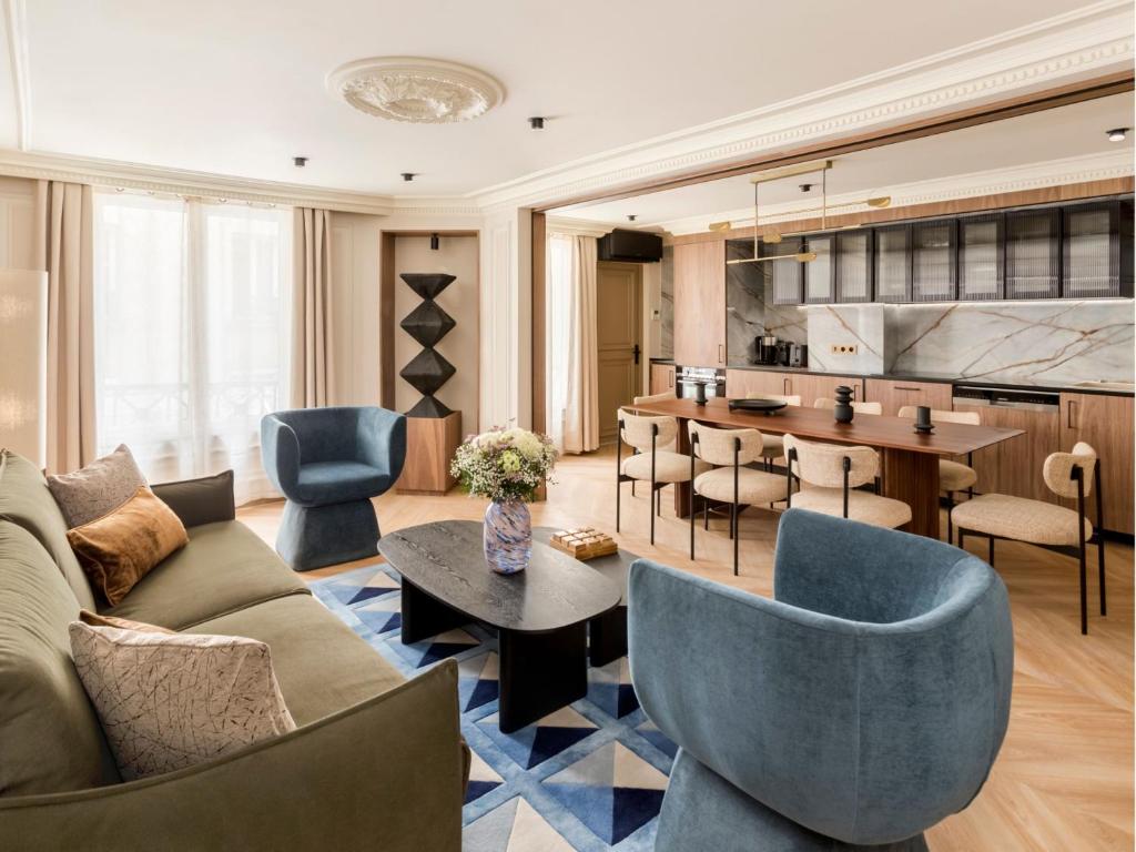 un salon avec un canapé et une table dans l'établissement Merveil - Signature Suite - Opera - Bateliere, à Paris