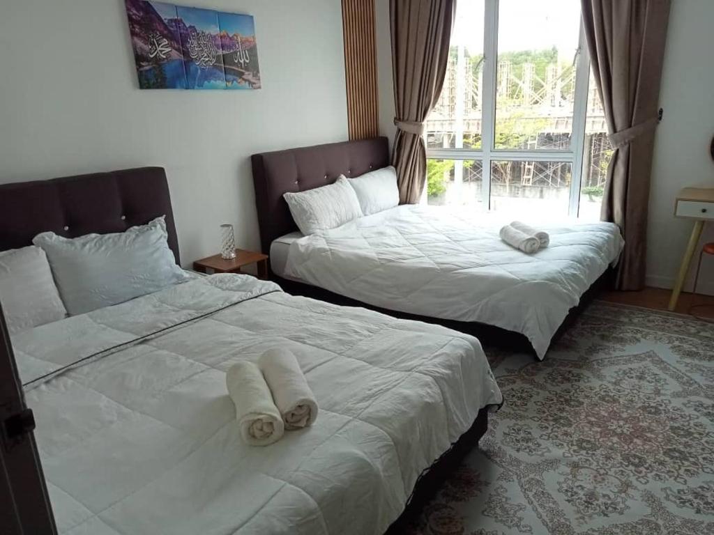 two beds sitting next to each other in a bedroom at Casa LiLa Homestay Private Pool Taman Kota Seribong Kota Bharu in Kampong Kubang Kachang