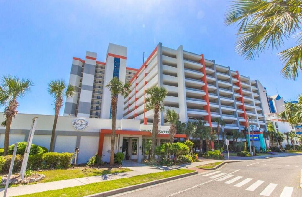 a large building with palm trees in front of it at Ocean Front Beach'n 1BR Premium Condos in Myrtle Beach