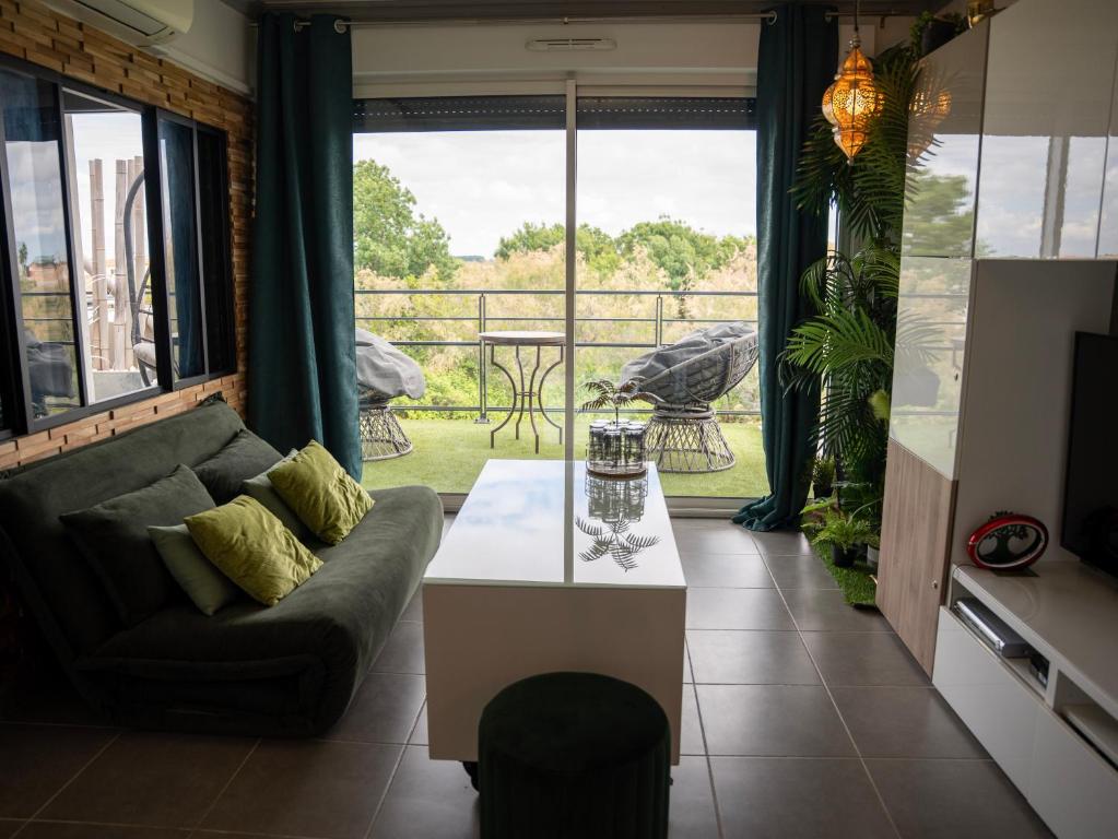 a living room with a couch and a table at Appartement de L'Espiguette in Le Grau-du-Roi