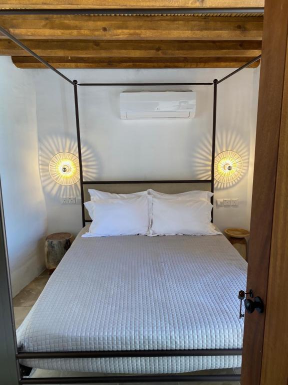 a bedroom with a canopy bed with two lights at SPITI Anastasia in Kathikas