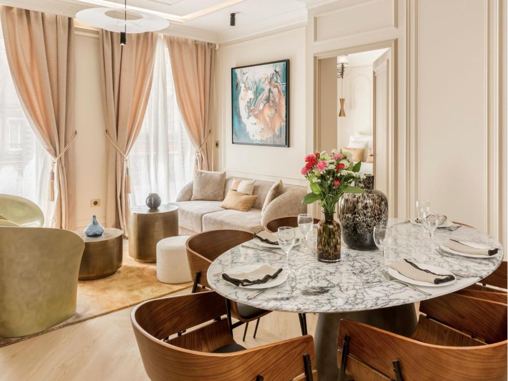 un salon avec une table, des chaises et un canapé dans l'établissement Merveil - Luxury Suite - Marais - Turbigo II, à Paris