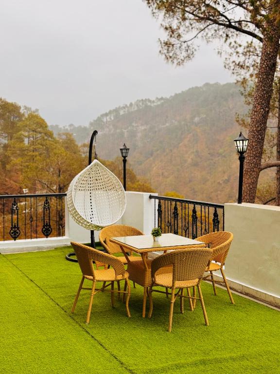 博瓦利Sitara Ambience Resort Halwani-Kaichi dham Bypass Road的露台上的草地上摆着桌椅