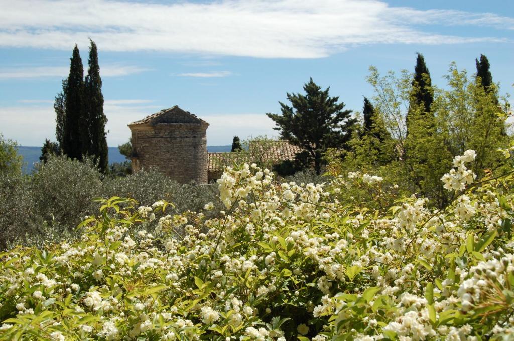 a field of flowers with a building in the background at Mas de la Beaume in Gordes